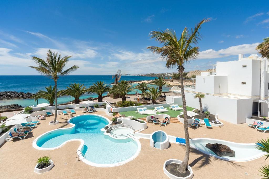 een afbeelding van een resort met een zwembad en de oceaan bij Neptuno Suites - Adults Only in Costa Teguise