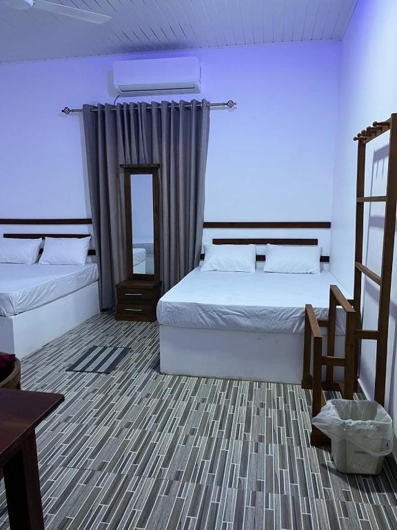 a bedroom with two beds and a mirror at Luma Residence Anuradhapura in Anuradhapura
