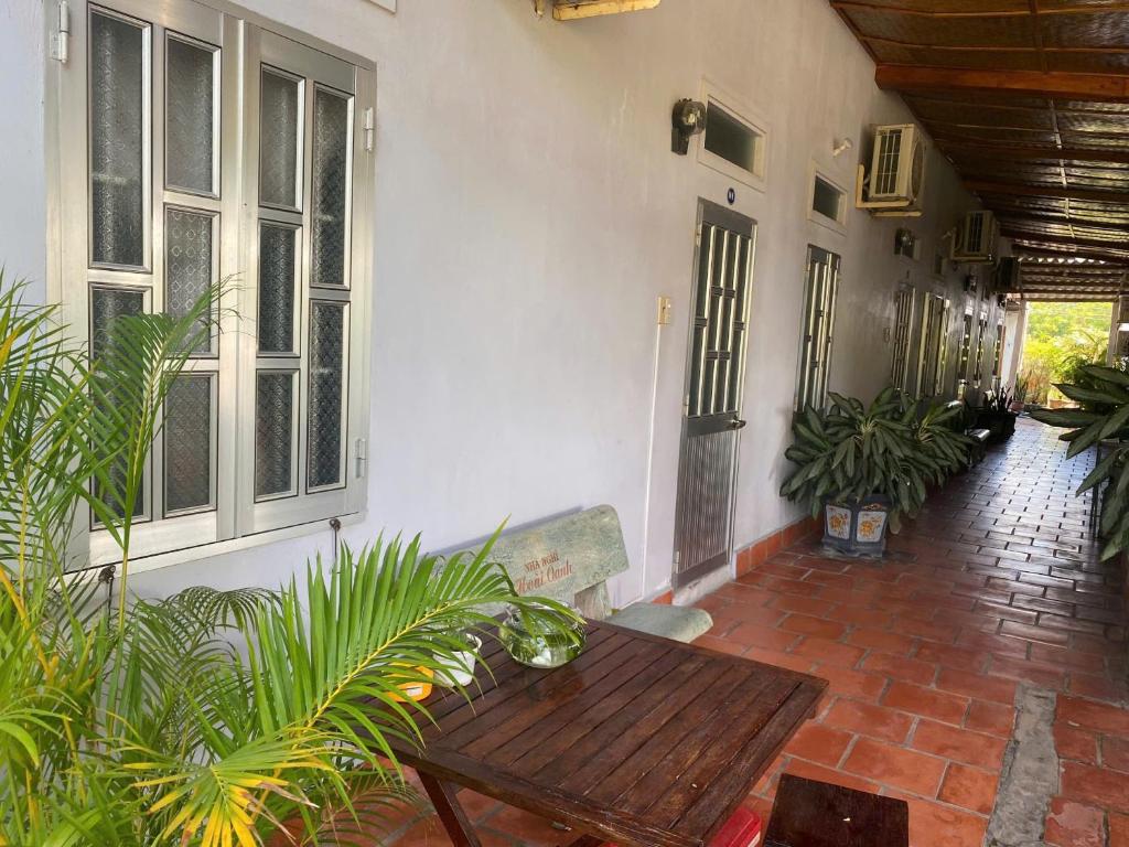 patio con tavolo in legno e alcune piante di Hoài Oanh homestay a Mui Ne