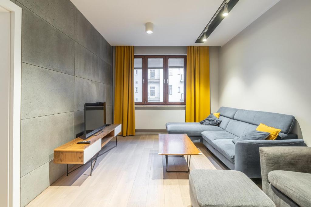 a living room with a couch and a tv at Zabrska 18 Spacious Apartment by BookingHost in Katowice