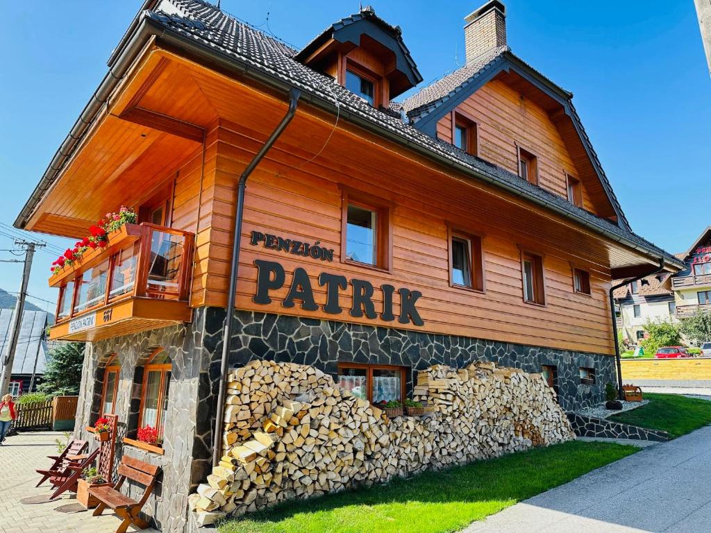 a wooden house with a pile of fire wood at Penzión Patrik in Ždiar