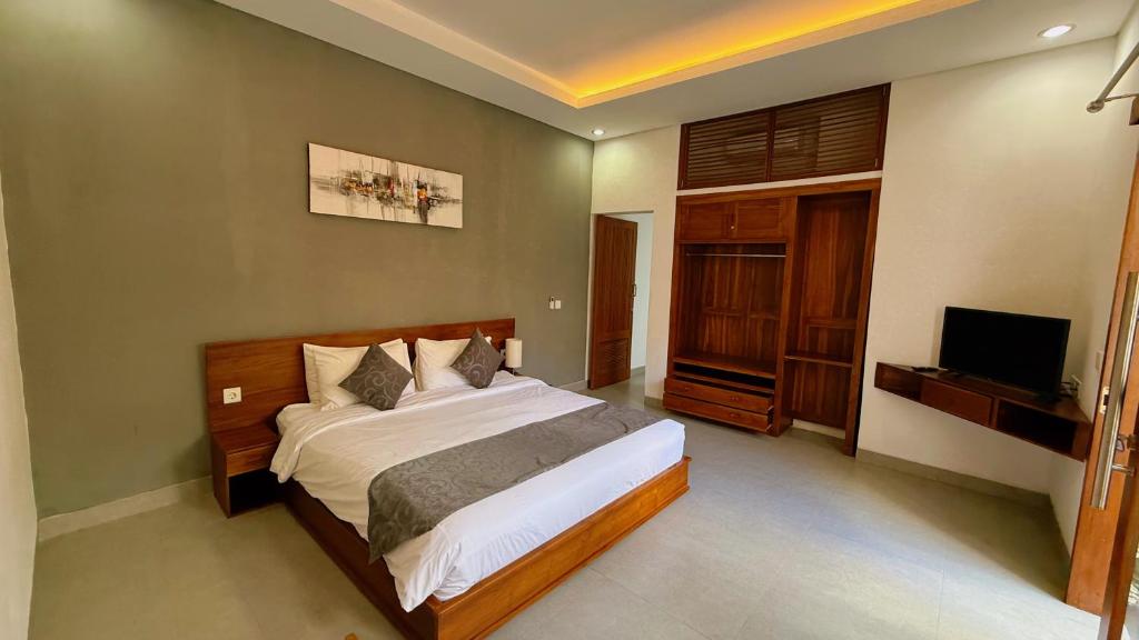 a bedroom with a bed and a flat screen tv at Villa Leyan 1 Semer - Between Seminyak & Canggu in Seminyak