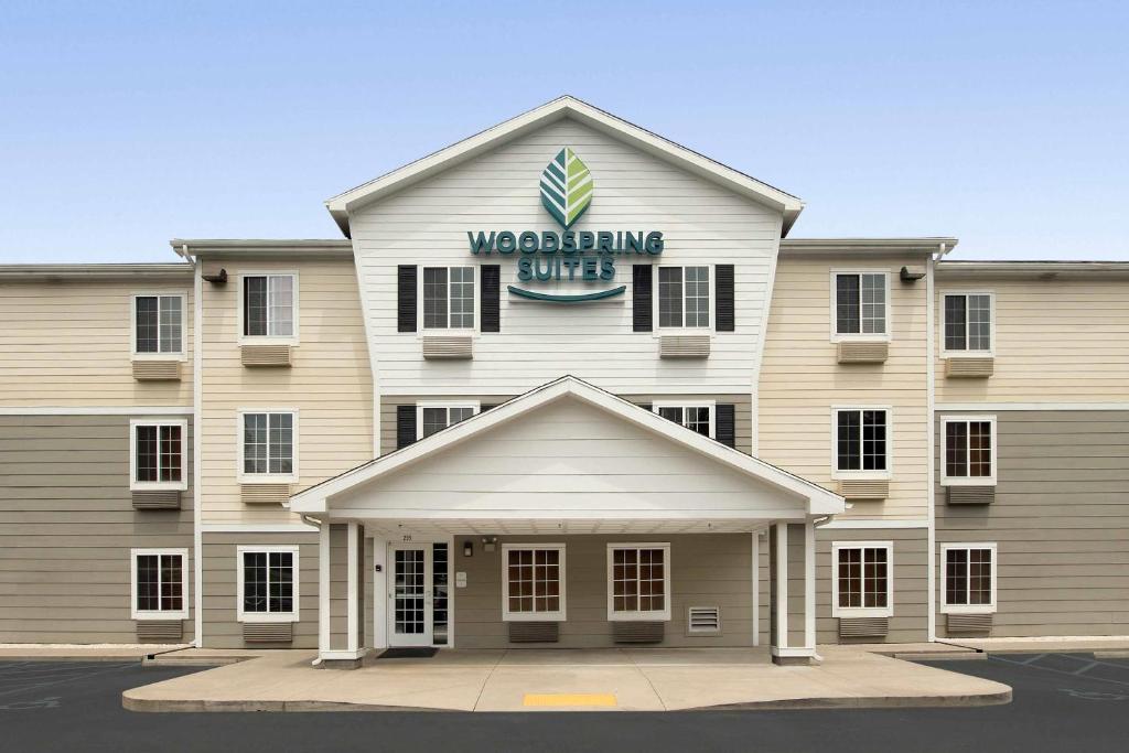 a building with a sign on top of it at WoodSpring Suites Spartanburg - Duncan in Duncan