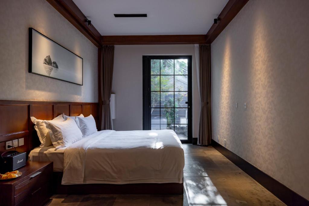 北京YiPiao Courtyard Hot Spring Resort Xiaotangshan Beijing的一间带大床和窗户的卧室