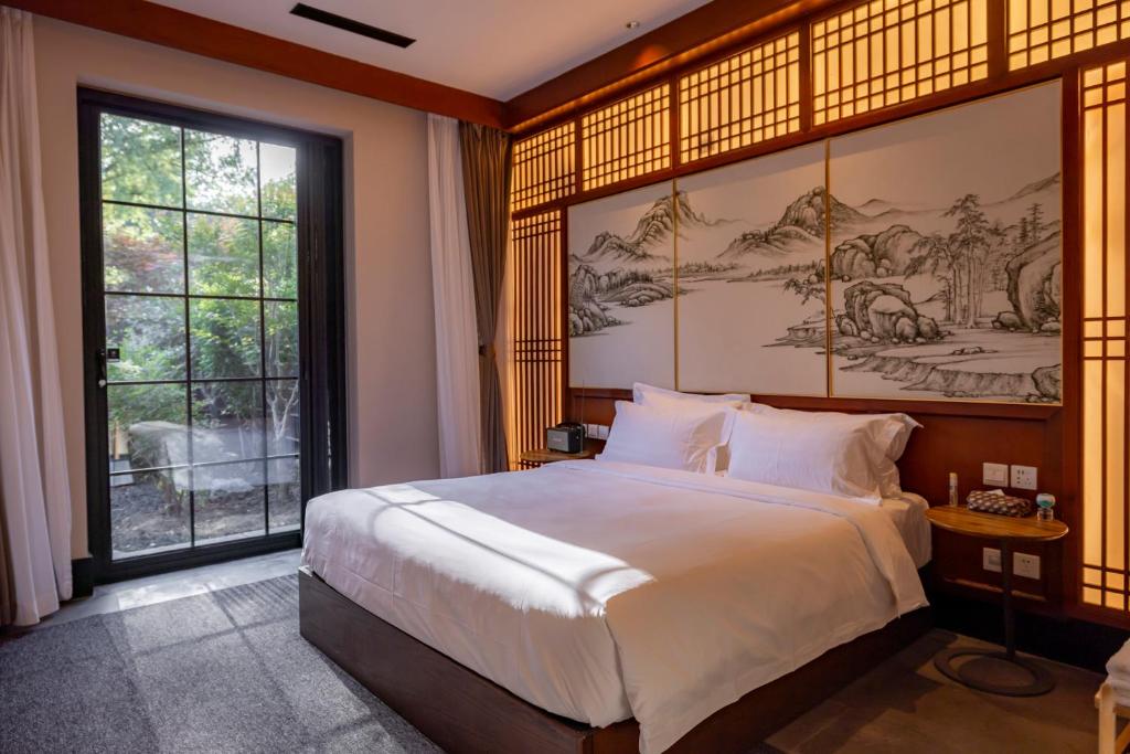 北京YiPiao Courtyard Hot Spring Resort Xiaotangshan Beijing的一间带大床和大窗户的卧室