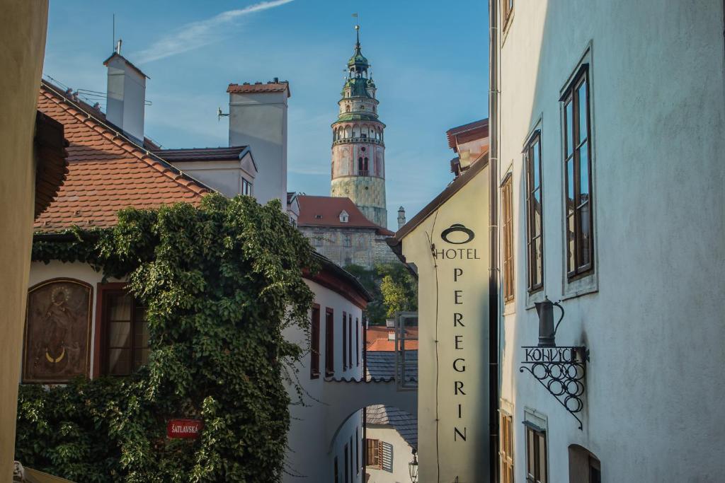 una calle de la ciudad con una torre del reloj en el fondo en Hotel Peregrin, en Český Krumlov