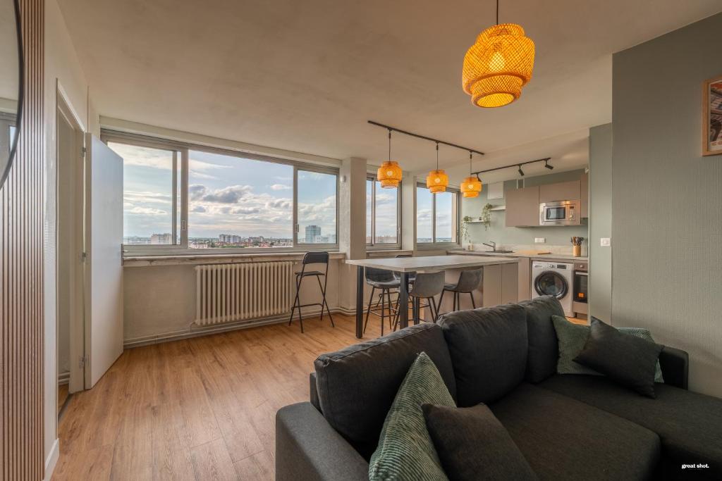 un salon avec un canapé et une cuisine dans l'établissement Toulouse Appartment 3 bedrooms balcony panoramic view - 10 min Train station & Metro, à Toulouse