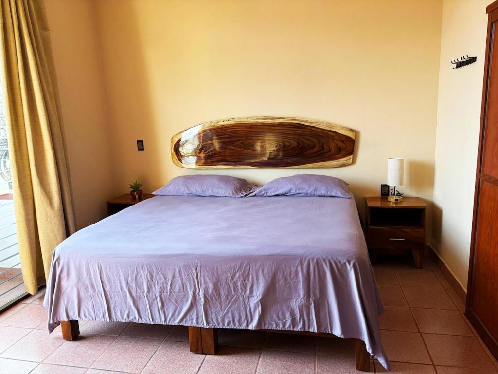 a bedroom with a bed with a large wooden headboard at Departamento Fila in Puerto Escondido