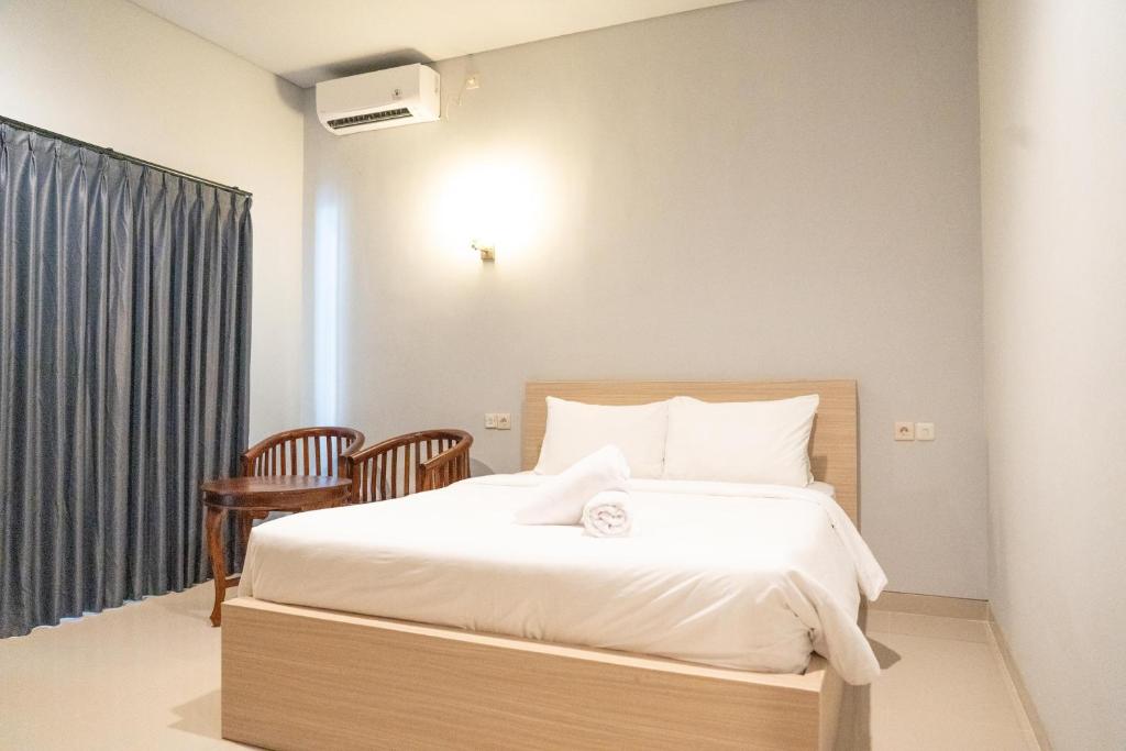 a bedroom with a bed and a table and chairs at The Joy Culinary & Room in Toyapakeh