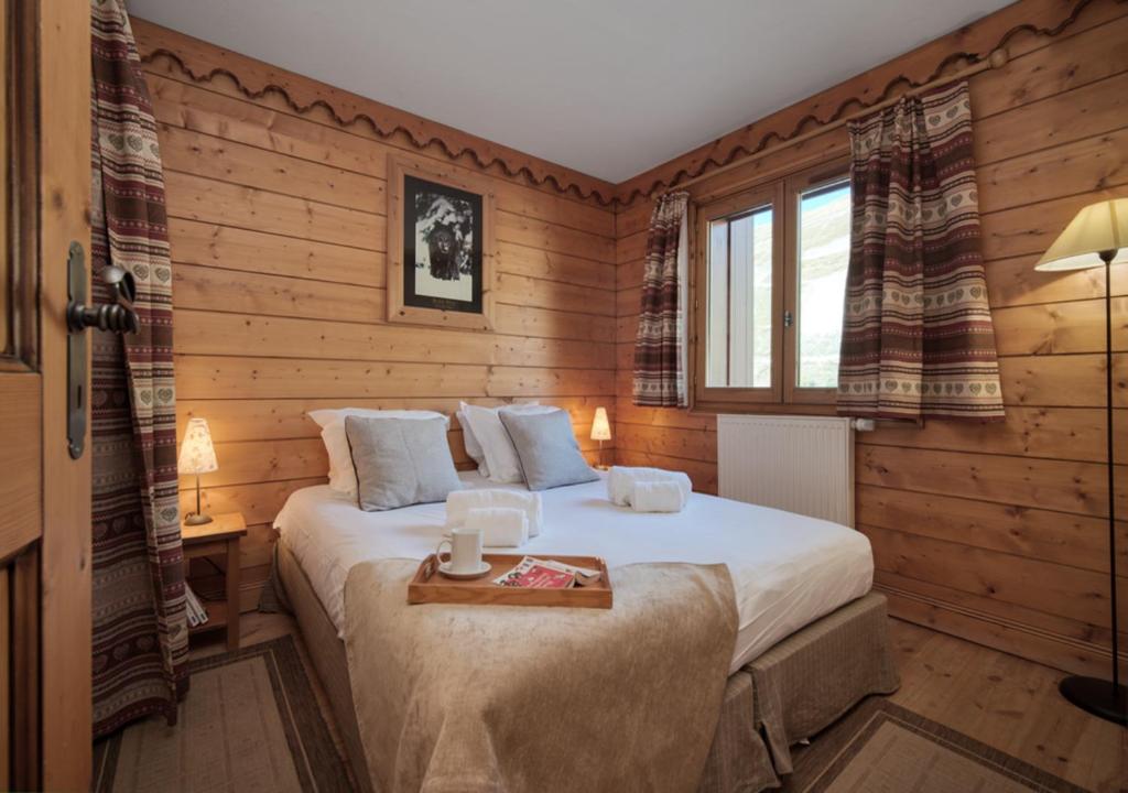 une chambre avec un lit avec un plateau dessus dans l'établissement Appartement Ecrin 214, à Tignes