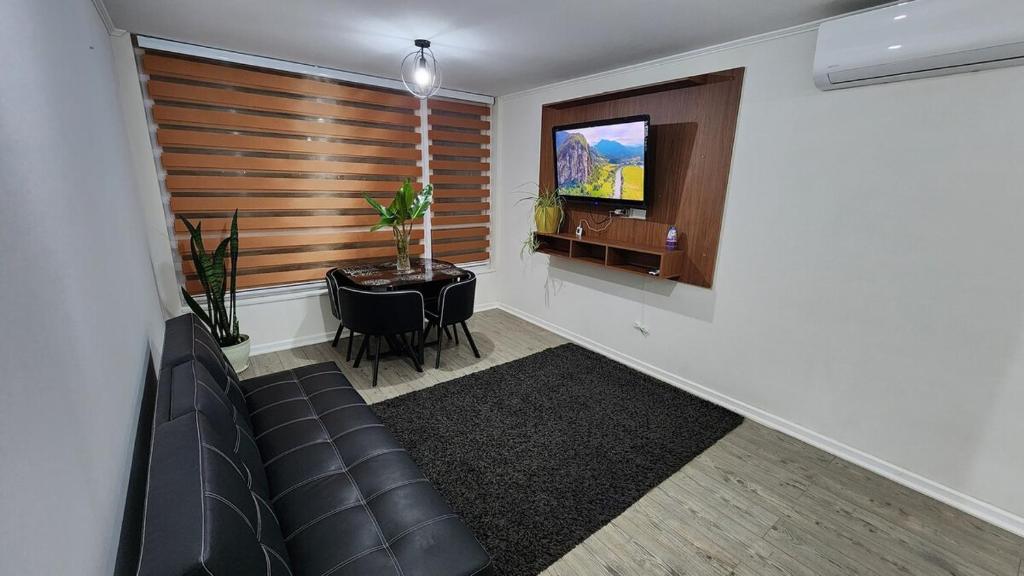 a living room with a couch and a table and a television at Comfortable y central depto 2D 2B with parking in Los Ángeles