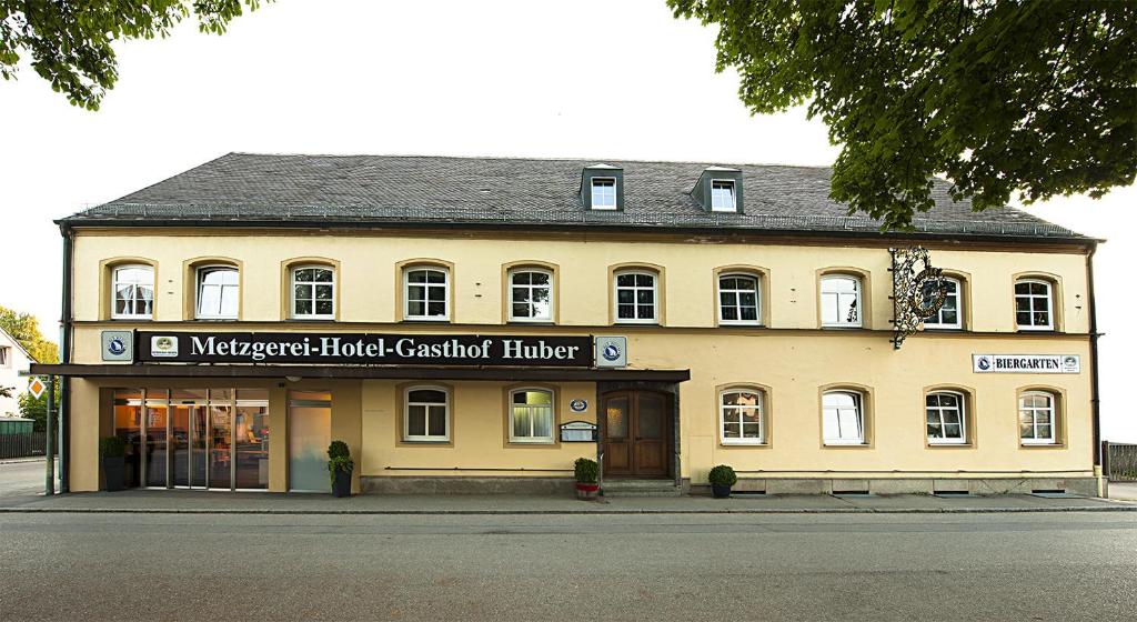 a large yellow building on the side of a street at Hotel Huber in Moosburg