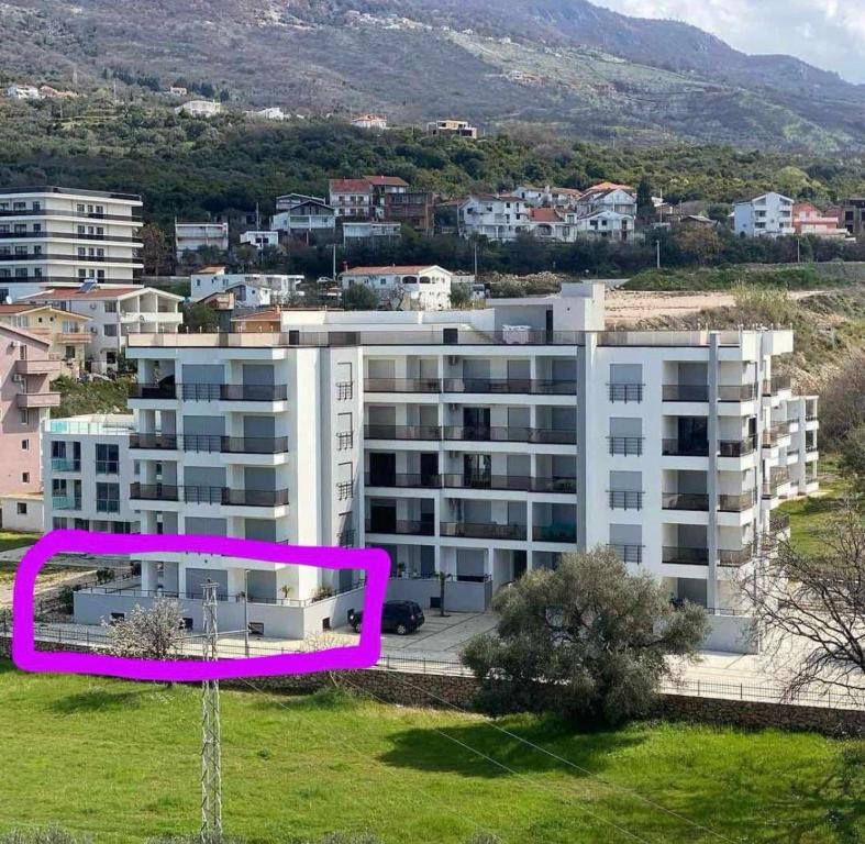 ein großes weißes Wohnhaus mit einem violetten Rechteck in der Unterkunft Ars Dobra Voda in Dobra Voda