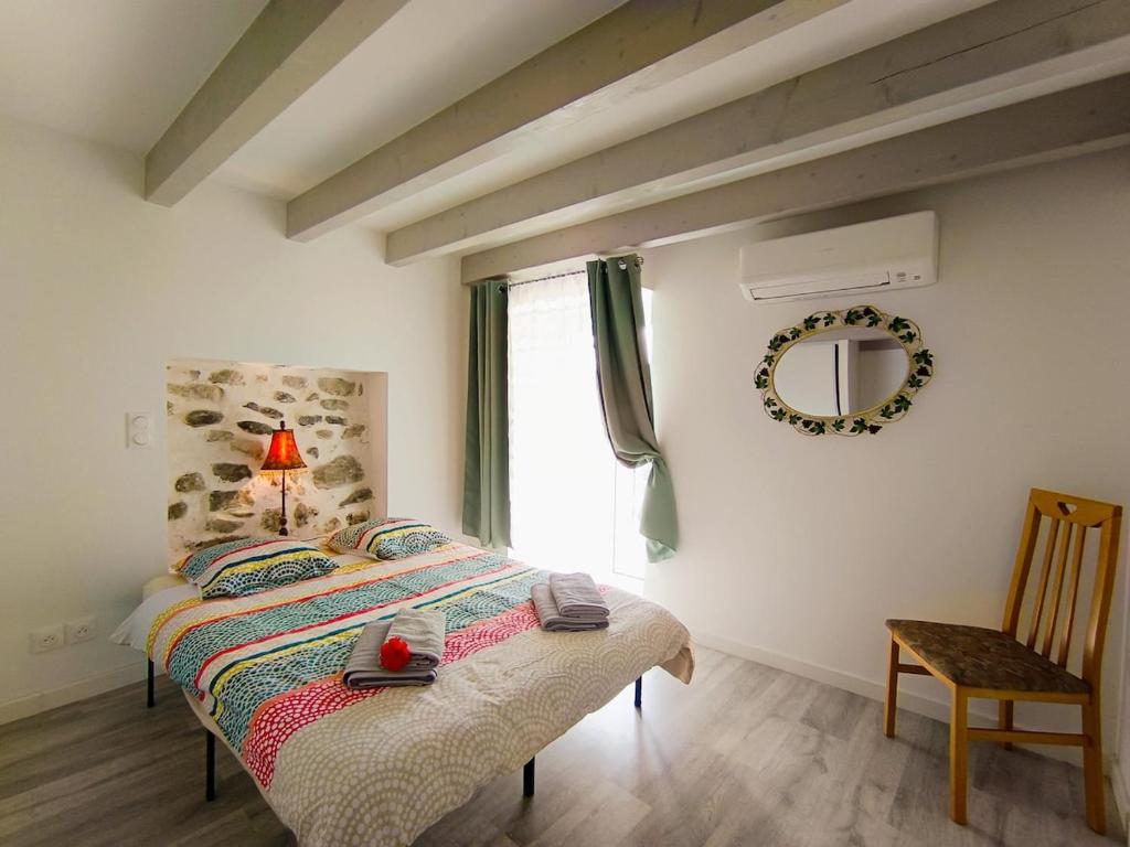 a bedroom with a bed with a lamp and a window at L'écrin de Sisteron - lac, centre-ville et parking in Sisteron