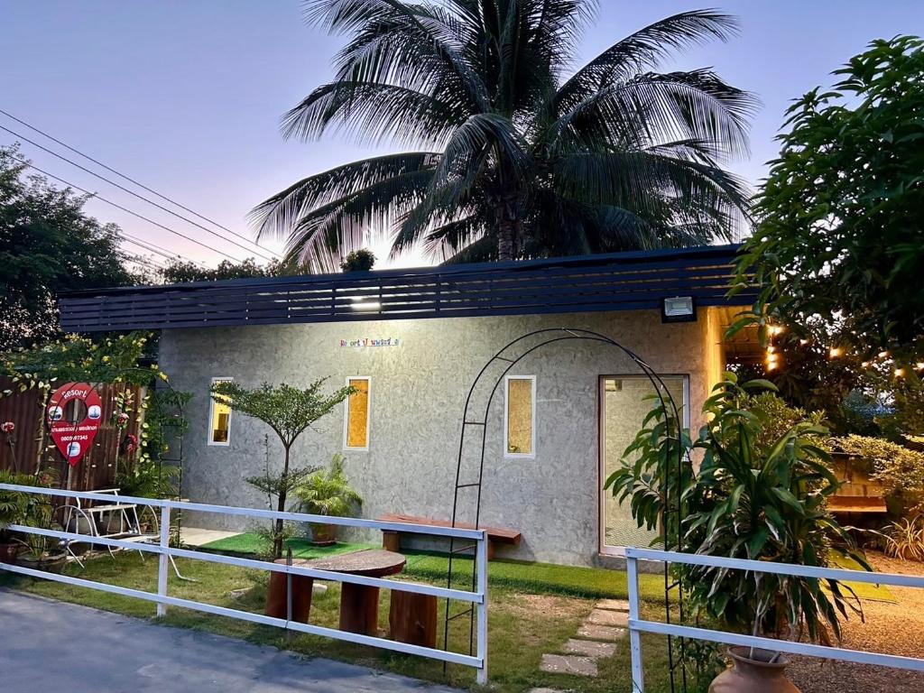 ein Haus mit einer Palme davor in der Unterkunft รีสอร์ทบ้านพระร่วง 