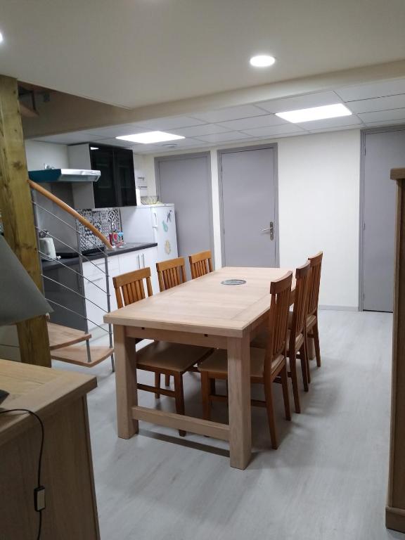 une cuisine avec une table et des chaises en bois dans l'établissement AU COEUR de la TOURAINE, à Ballan-Miré