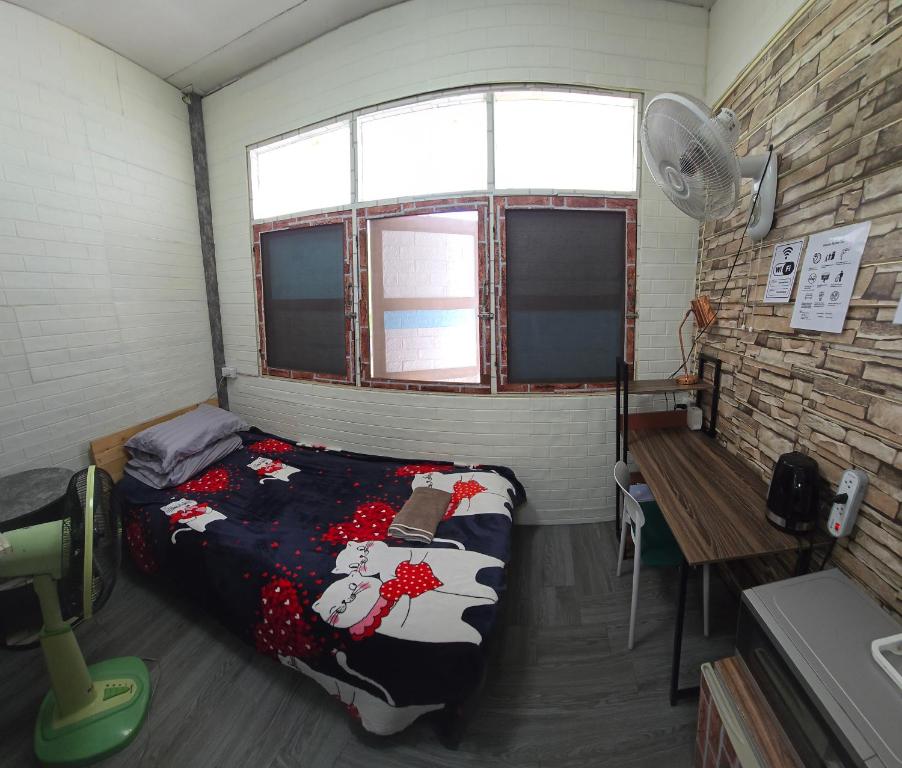 una stanza con un letto, una scrivania e una finestra di 206 Olan Place Apartment with free Wi-Fi a Bangkok