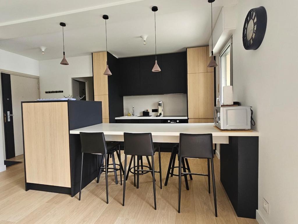 une cuisine avec une table et des chaises dans une pièce dans l'établissement Annecy centre , Vue lac, ascenseur 4 pers, à Annecy