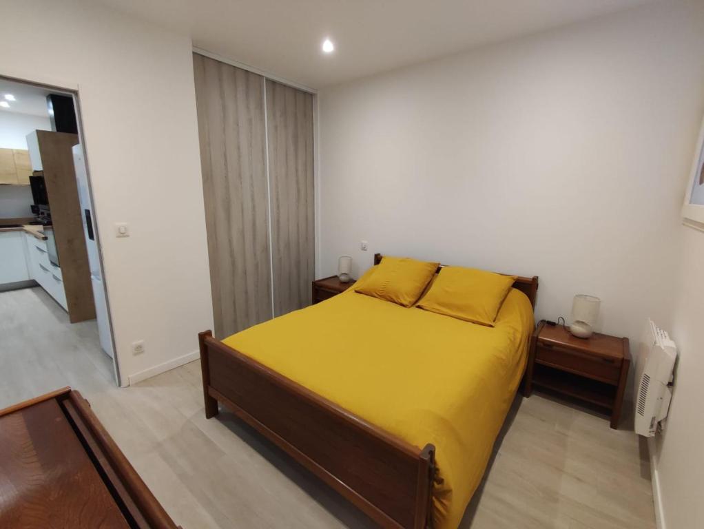 une chambre avec un lit avec une couverture jaune dans l'établissement chez mapi, à Saint-Jean-Pied-de-Port