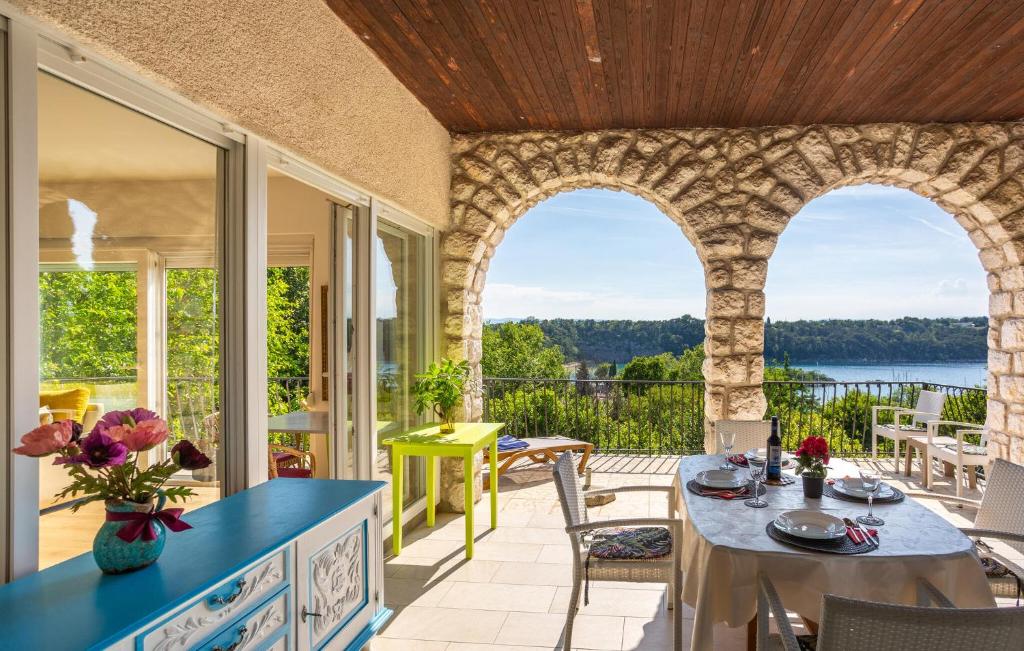 オミサリにあるOne Bedroom Beautiful Home In Omisaljのパティオ(テーブル、椅子付)が備わるアパートメントです。