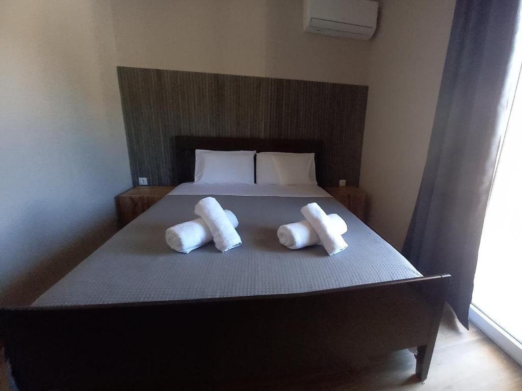 a bed with two pillows on top of it at Akrata Green Elite Apartments in Akrata