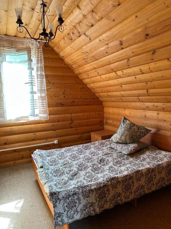 a bedroom with a bed in a log cabin at Деревяшка in Kara-Oy