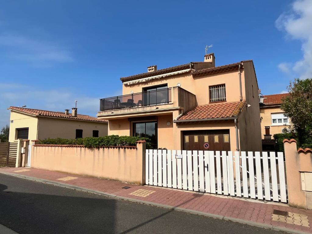 une clôture blanche devant une maison dans l'établissement VUE MER Maison individuelle 30 m de la plage 4 chambres 10 couchages jardin parking LXRM26, à Portiragnes