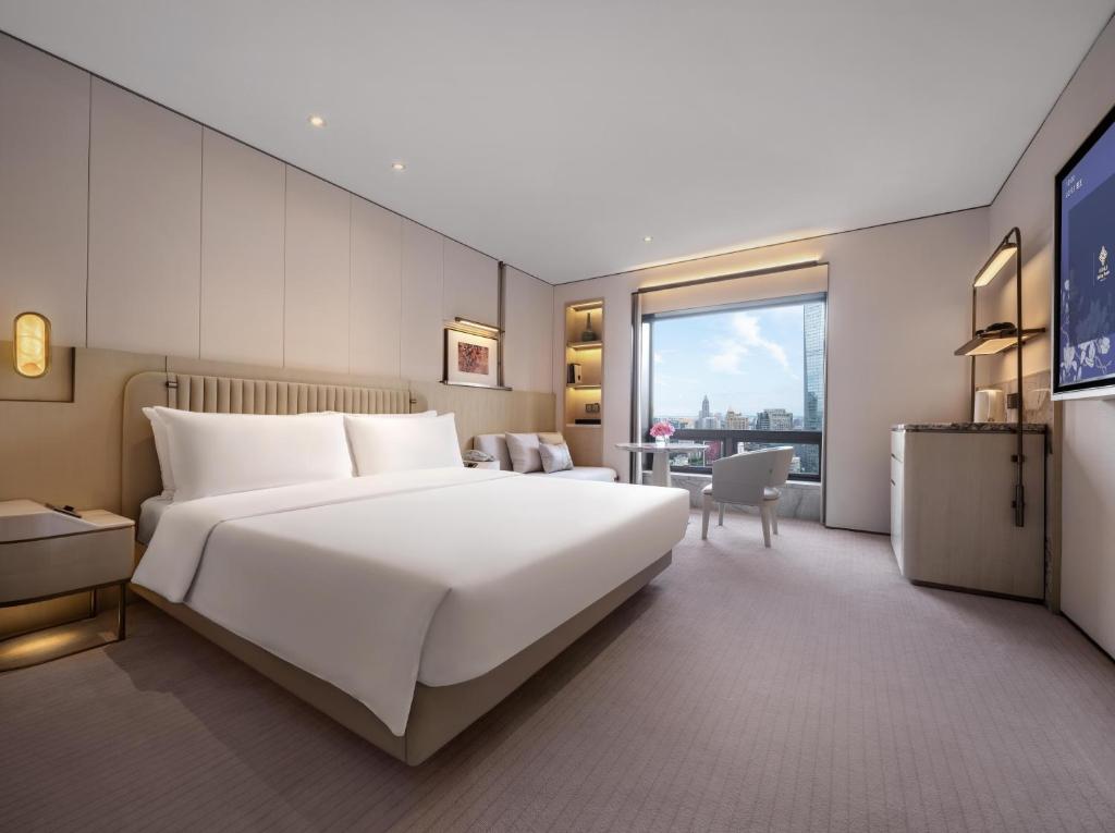 Postel nebo postele na pokoji v ubytování Jinling Hotel