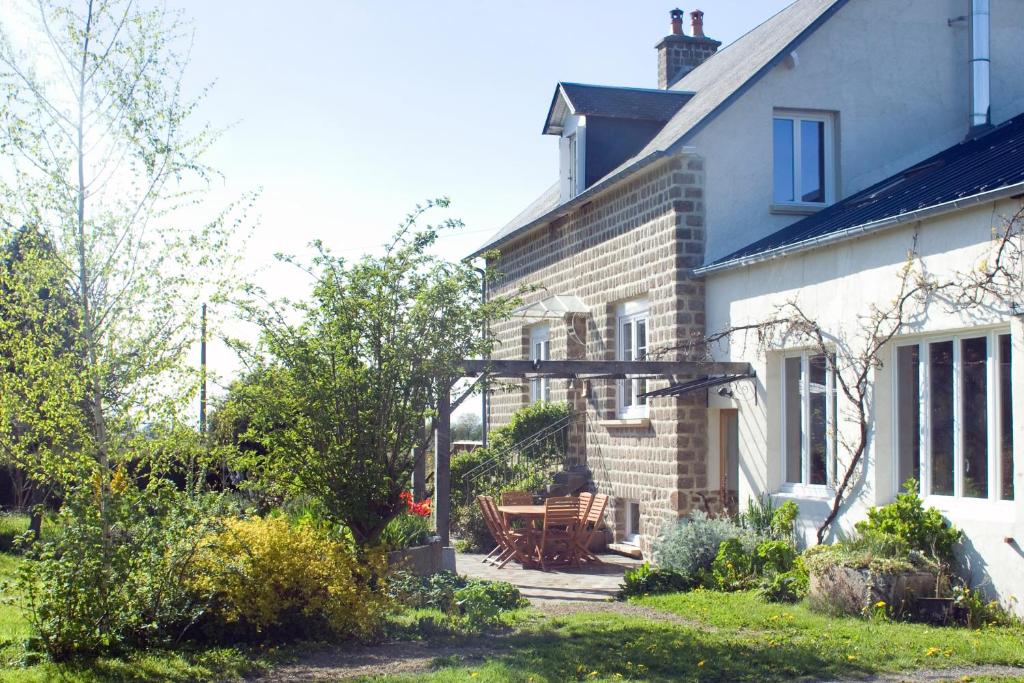 a house with a picnic table in front of it at La Nesliere Chambres d'Hôtes Bio in Saint-Symphorien-des-Monts