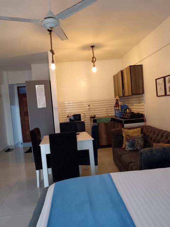 Una sala de estar y una cocina con un sofá y una mesa. en 5 Minutes to the Beach - Studio, en Mombasa