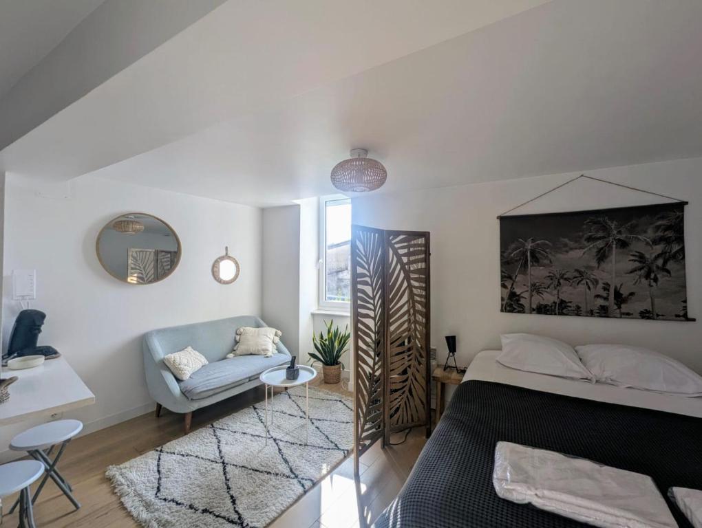 une chambre avec un lit, un canapé et une table dans l'établissement Cosy Space rue des Cloutiers, à La Rochelle