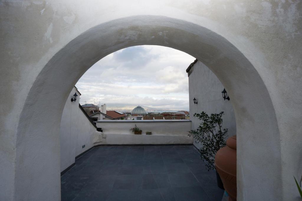 an archway on a balcony with a view of a city at Attico San Mattia in Naples