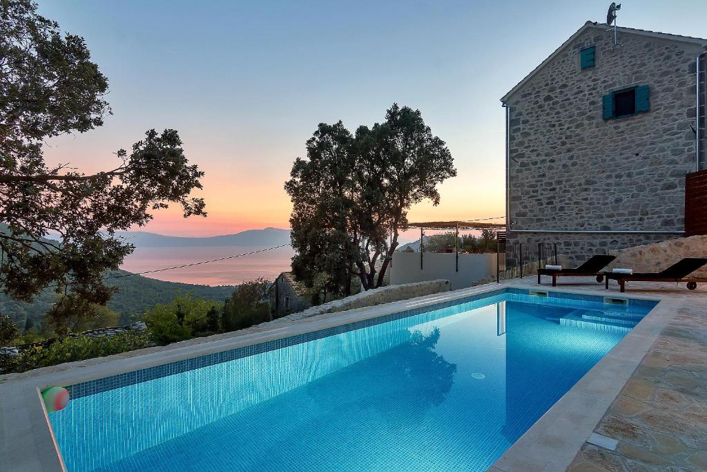 a swimming pool in front of a building at Villa Ante in Zaostrog