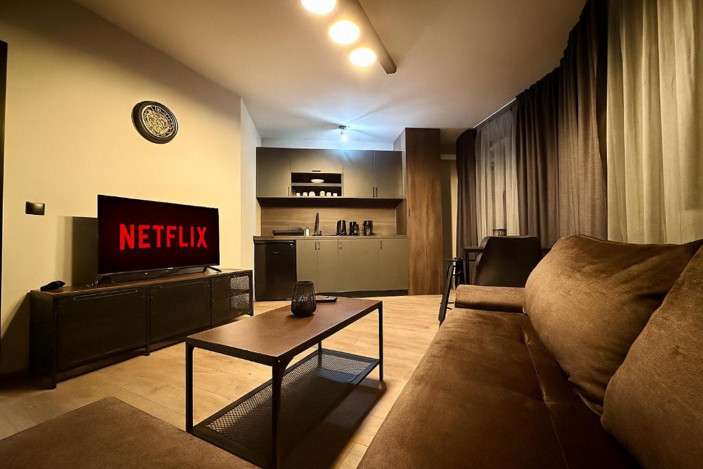 a living room with a couch and a tv at Elite Apartments Complex Iglika Borovets in Borovets