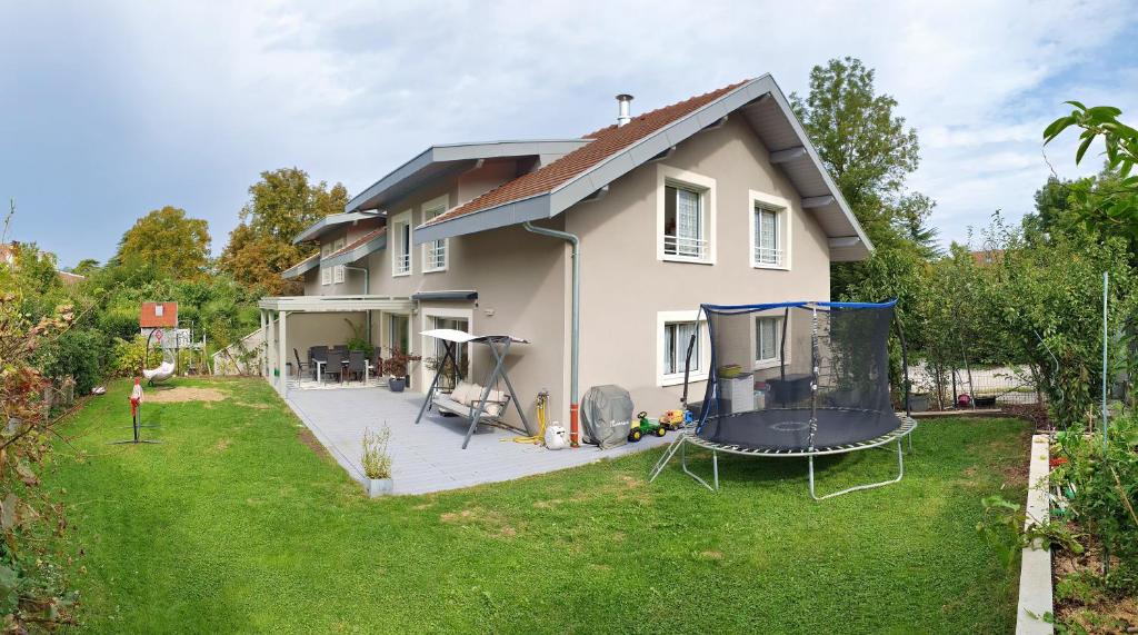 une maison avec une cour et une balançoire dans l'établissement Maison familiale - Jardin, à Collonges-sous-Salève