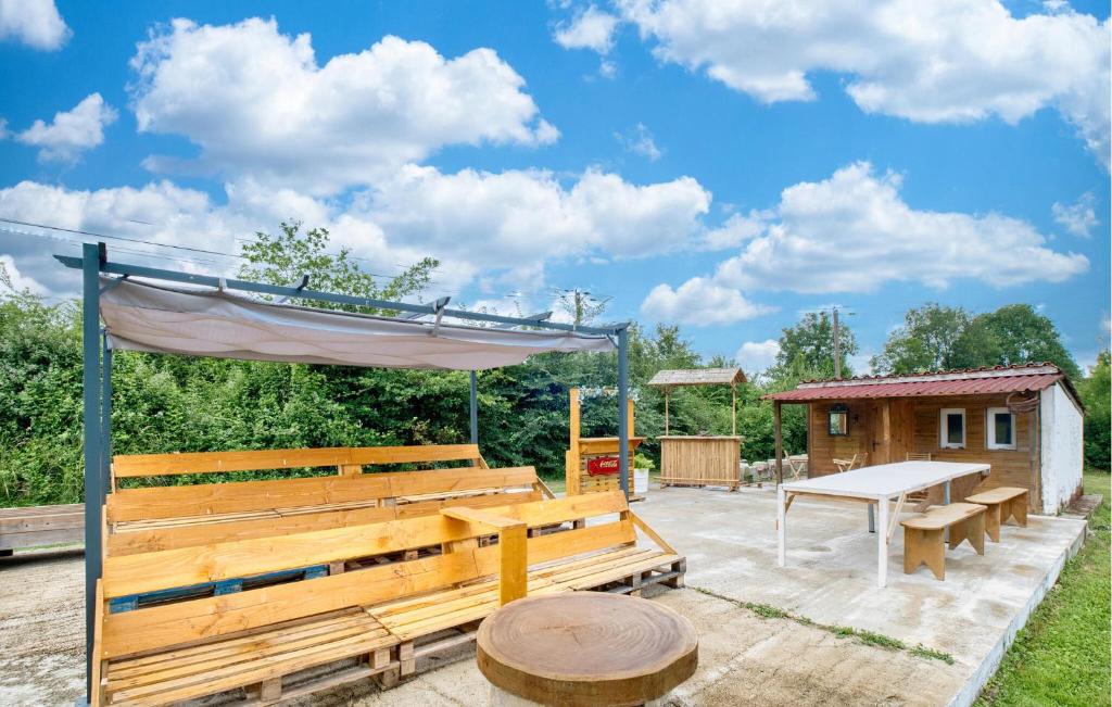 einer Holzbank und einem Picknicktisch im Hof in der Unterkunft Charmante Maison À La Campagne in Bourg-du-Bost