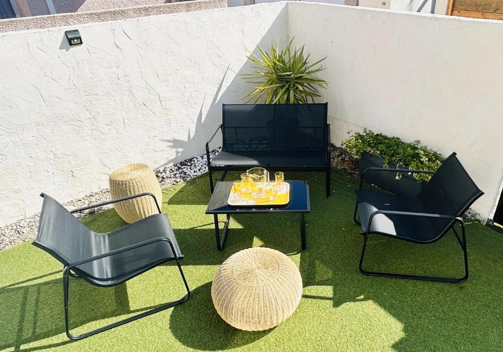 un groupe de chaises et une table sur une terrasse dans l'établissement La Maison de la Gardiole, à Frontignan