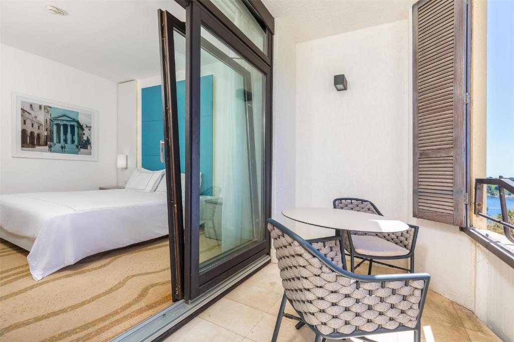 a room with a bed and a table and chairs at Park Plaza Histria Pula in Pula