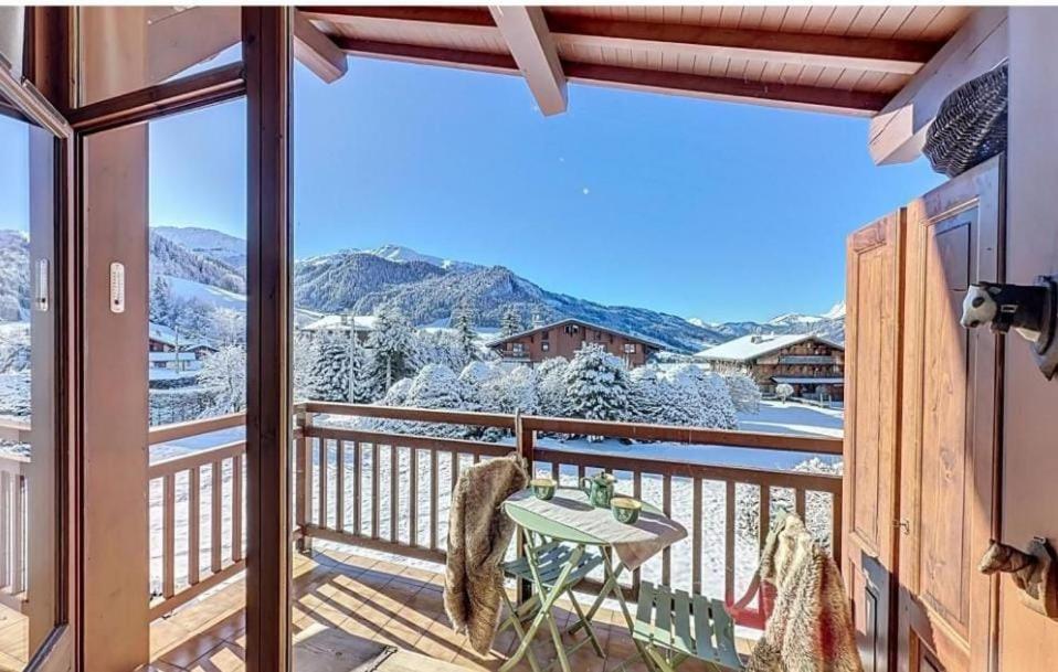 d'un balcon avec une table et une vue sur les montagnes enneigées. dans l'établissement Le Refuge de Rochebrune - vue montagne, à Megève