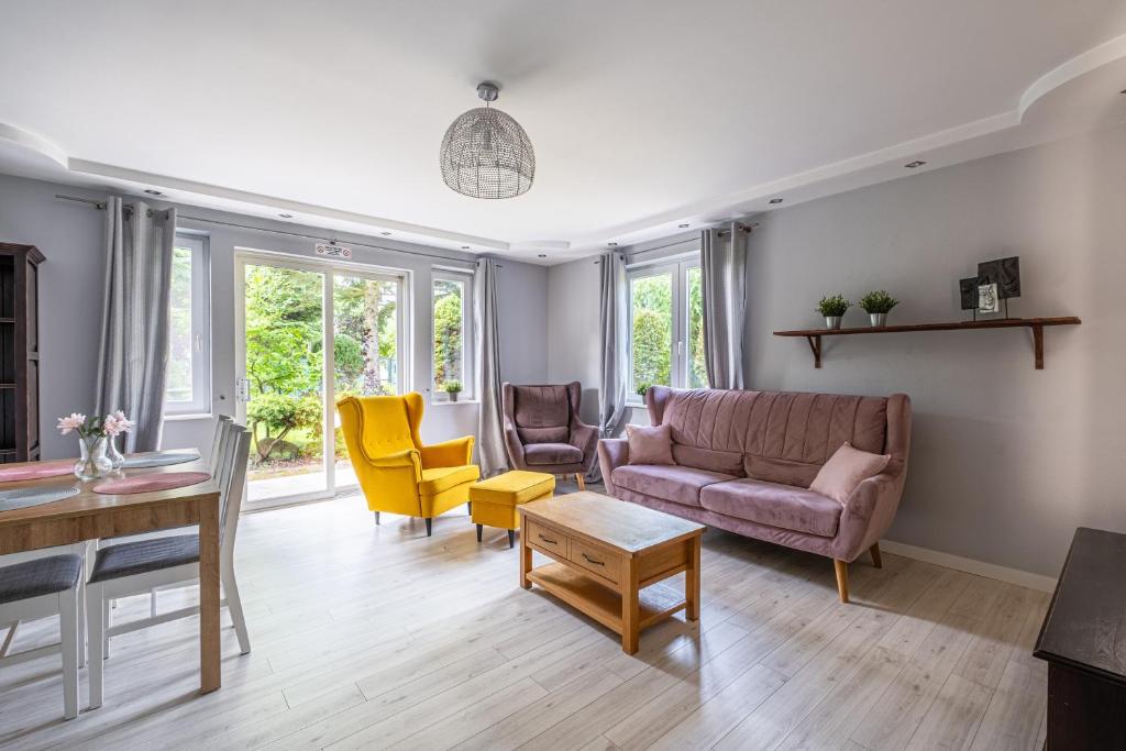 een woonkamer met een bank en stoelen bij Sunny Sobieszewo in Gdańsk