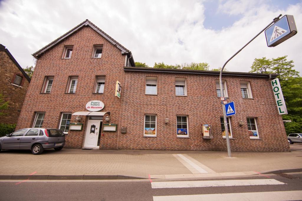 a brick building with a car parked in front of it at Hotel Burghof in Stolberg