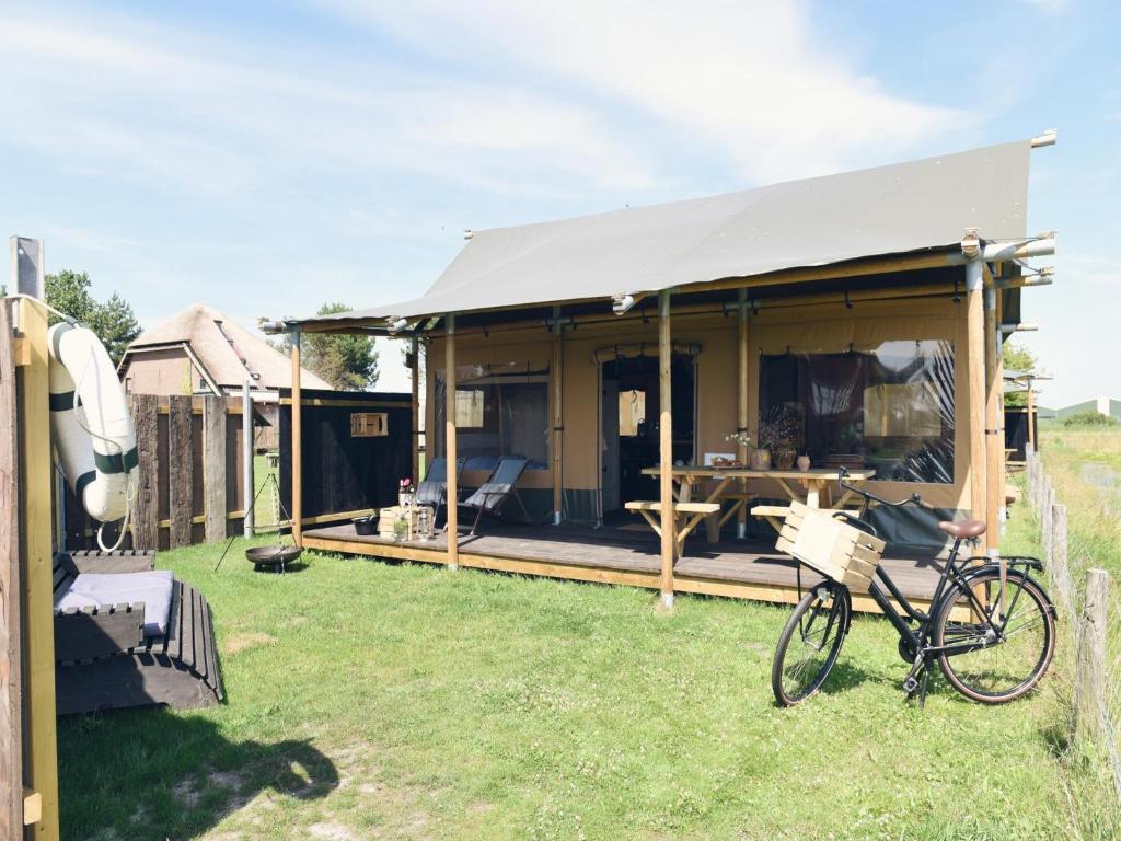 Una bicicleta estacionada en el césped junto a una casa en Beach Lodge Callantsoog near Dunes, en Callantsoog