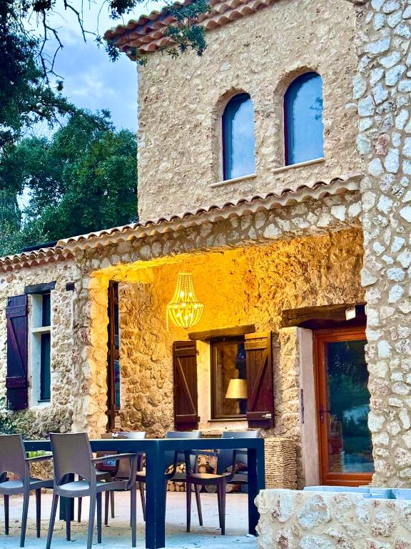 une table et des chaises devant un bâtiment en pierre dans l'établissement Maison Martens Villa & Appartement, à Lorgues