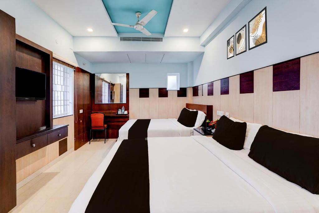 チェンナイにあるSuper Townhouse Chennai Near Airport Formerly Sai Bala Budgetのベッド2台と薄型テレビ付きのホテルの部屋