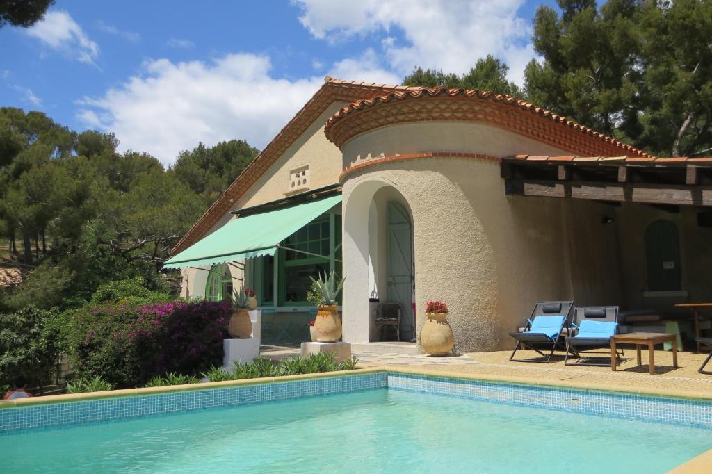 a house with a swimming pool in front of it at Cassis Hostel in Cassis