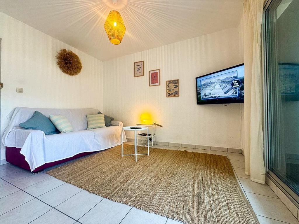 une chambre avec un lit et une télévision à écran plat dans l'établissement Le BarcaBulle, au Barcarès