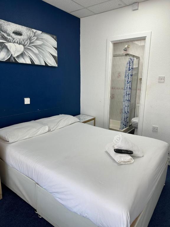 a bedroom with a large white bed with a blue wall at The Regency Hotel in Blackpool