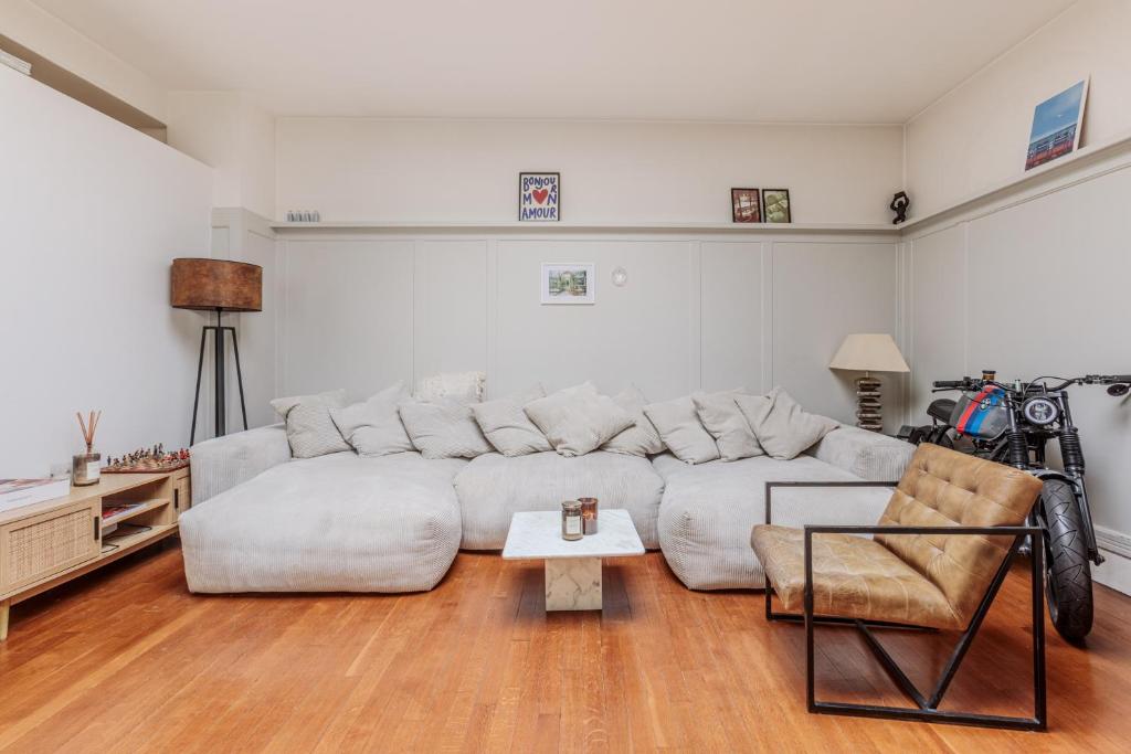 un salon avec un canapé blanc et une table dans l'établissement Paul Escudier - Spacieux et lumineux appartement au cœur de Paris, à Paris