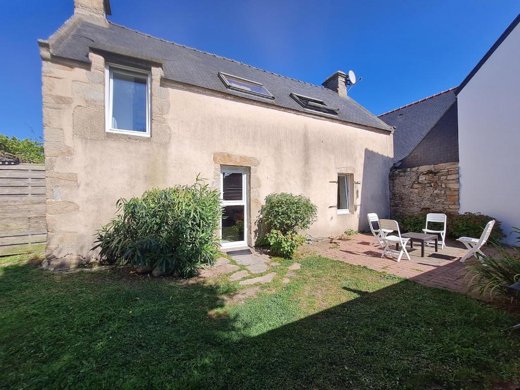 une maison avec deux chaises et une table dans la cour dans l'établissement Kervihan village house, à Saint-Pierre-Quiberon