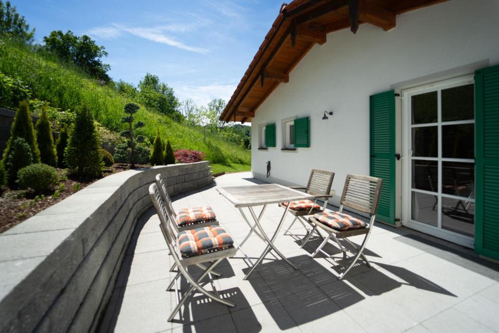 a patio with two chairs and a table on a wall at Chalet Chip-In Golf Wandern Berge in Oberuttlau
